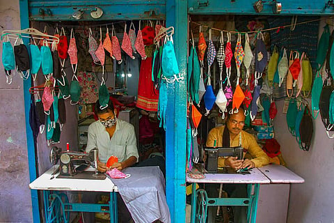 Representative image of tailors stitching face masks