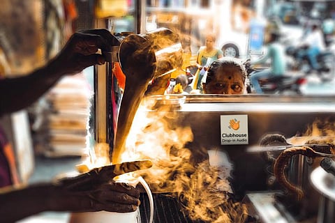 Man in a tea shop pouring team from glass to vessel
