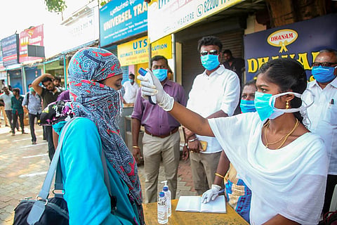 A passenger being examined for coronavirus using thermal screening device