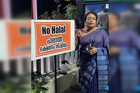 Tushara Ajith, Kerala entrepreneur standing next to a board that says 'non-Halal restaurant'