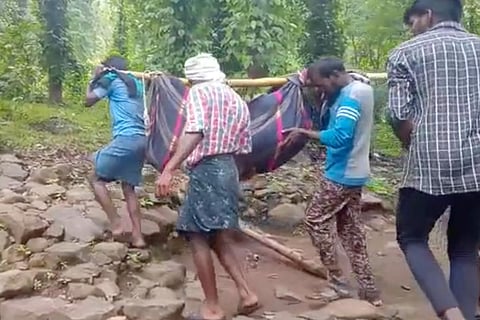Tribal man carried in a makeshift stretcher in Nilgirils