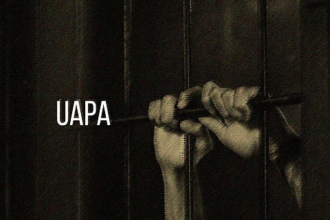Two hands holding bars and the letters UAPA