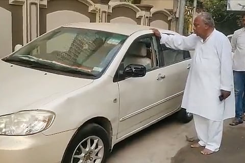 V Hanumantha Rao inspects a car that got damaged during stone pelting on his Hyderabad home