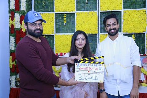Vaisshnav Tej and Ketika Sharma seen alongside Sai Dharam Tej clapping the board in the puja ceremony.