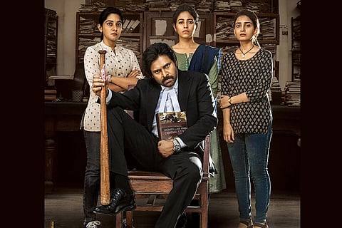 Vakeel Saab Poster with Pawan Kalyan sitting in a chair, Nivetha Thomas, Anjali and Ananya Nagalla standing behind him