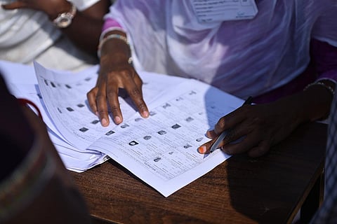 A polling officer checking voters list at the time of voting