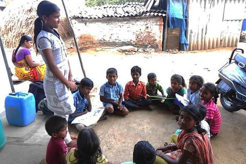 Students from a basti are sitting around and participating in child parliament session
