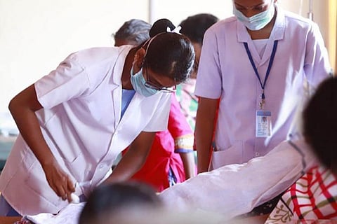 Nurse tending to a patient in corona ward