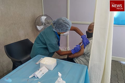 A man receives the first dose of COVID-19 vaccine from a health worker