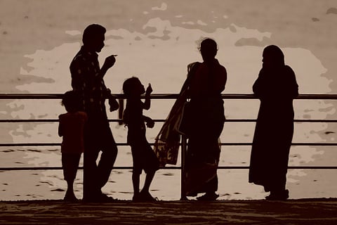 A representative image of a family of five on a beach in an evening