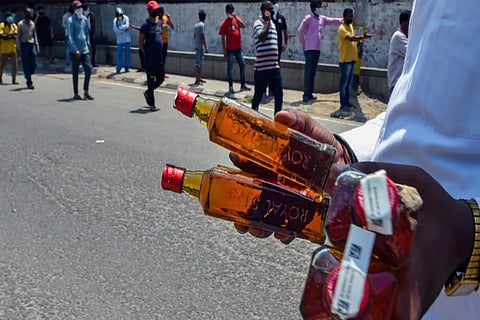 Image of a man holding liquor bottles