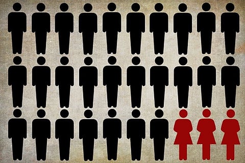 Silhouette icons of twenty-eight people in a grid. Twenty-five are black and arranged in rows of five, and three at the bottom right are red and shaped like women. The background is a textured, neutral color.