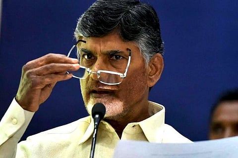 Chandrabab Naidu holds his spectacles and set of documents