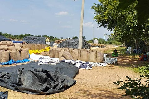 Farmers wait with their produce at a paddy procurement centre in Telangana