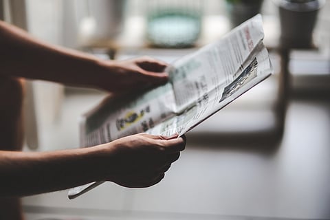 A person holding the newspaper