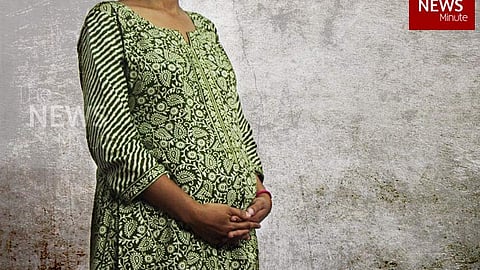 Image of a pregnant woman in a green printed kurta, visible only from the neck down.