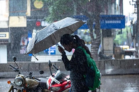 A woman walking with an umbrella in heavy rain