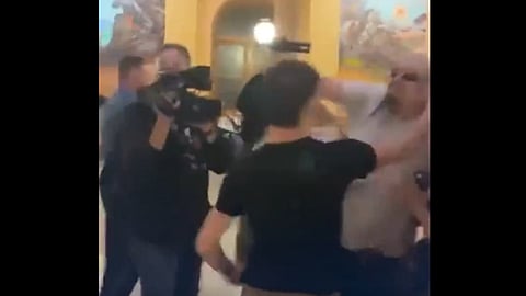 Satanic Grotto leader Michael Stewart punches a Catholic protester at the Kansas State Capitol