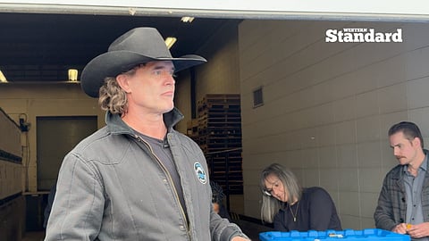 Corb Lund submitting his petition's signatures to Elections Alberta officials.