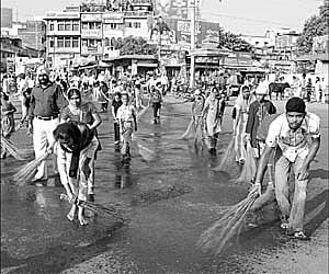 Members of Sikh community cleaning a road before taking out a procession in Rourkela on Tuesday ahead of 540th birth anniversary celebration