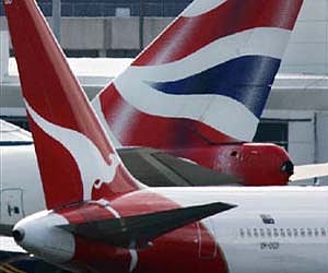 A Qantas passenger plane passes in front of the tail of a British Airways plane at Sydney airport in this September 2004. (File photo / REUTERS)