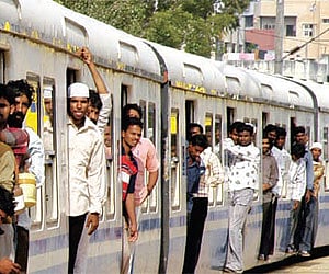 Commuters spill out of the general compartment of a crowded MMTS train in the city.