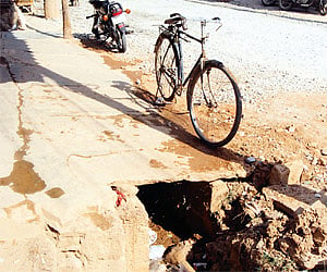 An apology for a footpath and a road that has not been asphalted properly. Such sights are common in K R Puram constituency