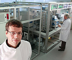 Adam (shown in background) with its two human 'colleagues' in the white coats. (Image courtesy: Aberystwyth University)