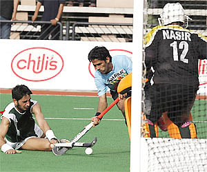 Shivendra singh, center, battles for control for the ball with Ashraf Zeeshan from Pakistan during the semifinals of Azlan Shah Cup in Ipoh. PTI