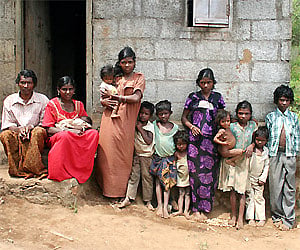 Gopalan and Kalyani with their 10 children, one of the tribal families near Sathram Colony at Vandiperiyar, in front of the house built by the block