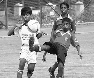 Players from Kannur (left) and Thiruvananthapuram battle for the ball at the Maharaja’s College Stadium in Kochi on Wednesday