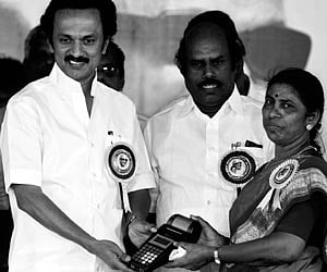 Deputy Chief Minister M K Stalin giving away a hand-held billing machine to a woman official in Tambaram on Monday.