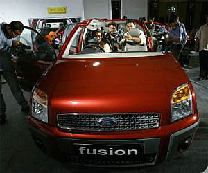 Media personnel cover the launch of the updated version of Ford Fusion car in New Delhi in this August 2006 file photo. Reuters