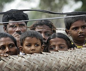 Internally displaced Sri Lankan Tamil civilians peep from over a fence at a camp for the displaced in Vavuniya, Sri Lanka, Saturday. (File photo / AP)