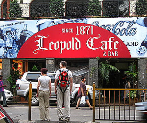 A couple of tourists in front of the Leopold Cafe in Mumbai. (Image reproduced as per the Wikimedia Commons license)
