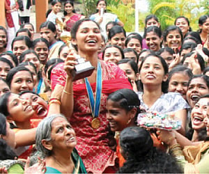 Friends carrying Sharmi Ulahannan on their shoulders during a reception at NSS College, Neeramankara.