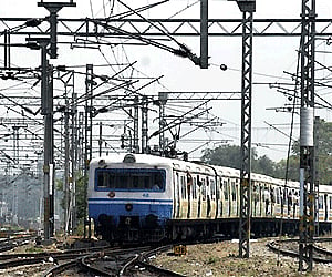 Passengers look on as they travel in a local train at Secunderabad railway Station in Hyderabad.