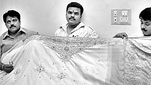 Weavers displaying a Dharmavaram silk saree. 