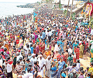 Devotees participating in the ‘Theerthavari’ ritual on Vaithikuppam beach, in Puducherry on Thursday.