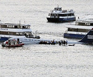 Passengers wait to board boats to be rescued on the wings of a US Airways Airbus 320 jetliner that safely ditched in the Hudson River in New York.(AP)