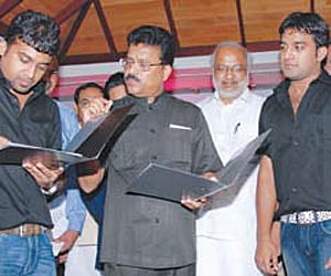 Mohan Abraham, director of CCE, signing the tie-up with MLSAT. Also seen are (from left) Samuel Devassy, Minister M A Baby, Stephen Devassy, drummer S