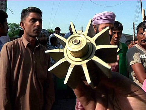 A resident shows a part of the mortar shell fired from the Pakistani side of the International Border Ramgarh sector in Langoor village near Jammu on Thursday | PTI