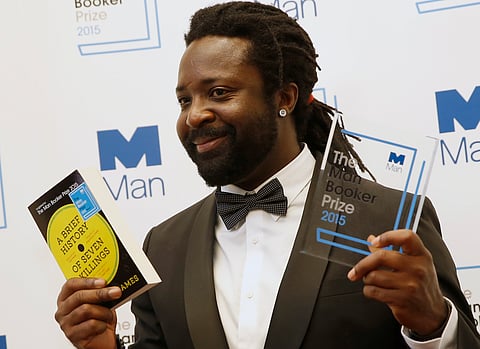 Jamaican author Marlon James holds his novel and the award after his book 'A Brief History of Seven Killings' was named as winner of the 2015 Booker Prize 2015 for Fiction, poses for photographers following the award ceremony at the Guildhall in London,