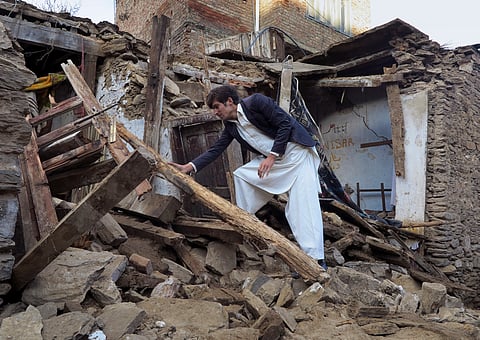 A Pakistani boy examines a house damaged caused by massive earthquake in Mingora, the main town of Swat valley, Tuesday, Oct. 27, 2015 | AP