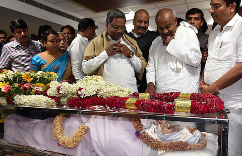 Chief Minister Siddaramaiah and former PM H D Deve Gowda paying tribute to BJP MLA Gurupadappa Nagamarapalli in Bengaluru on Tuesday. Minister Umashree looks on |Express photo