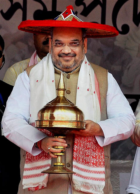 Caption: Guwahati BJP National President Amit Shah being felicitated with an Assamese Japi and Khoria during the BJP Janajagaran Samaroah at Khanapara in Guwahati on Sunday. 