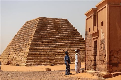 A Sudanese tour guide and a member of the security forces observes a temple at the Meroe pyramids site, in al-Bagrawiya, 200 kilometers (125 miles) north of Khartoum, Sudan. |AP
