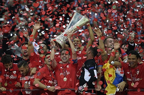 Sevilla players celebrate with throphy after the UEFA Europa League final football match between FC Dnipro Dnipropetrovsk and Sevilla FC at the Narodowy stadium in Warsaw, Poland. |AFP