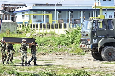 Security personnel carry the coffin of a victim's body after postmortem in India's northeastern state Manipur |AP