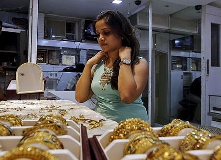 In this file photo, a woman tries on a gold necklace inside a jewellery showroom at a market in Mumbai, July 8, 2015 | Reuters